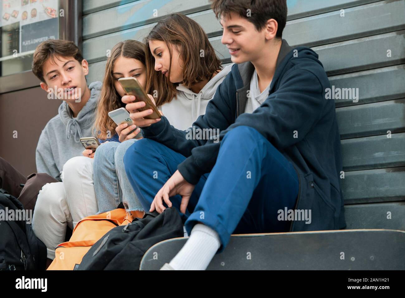 Amici che utilizzano lo smartphone all'aperto Foto Stock