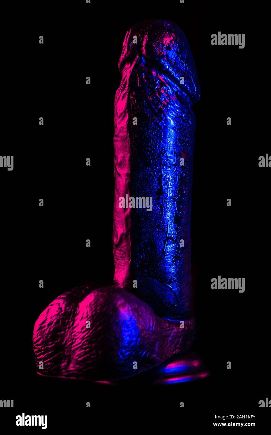 Dildo lubrificato subito dopo l'uso in blu e viola la luce al neon Foto Stock