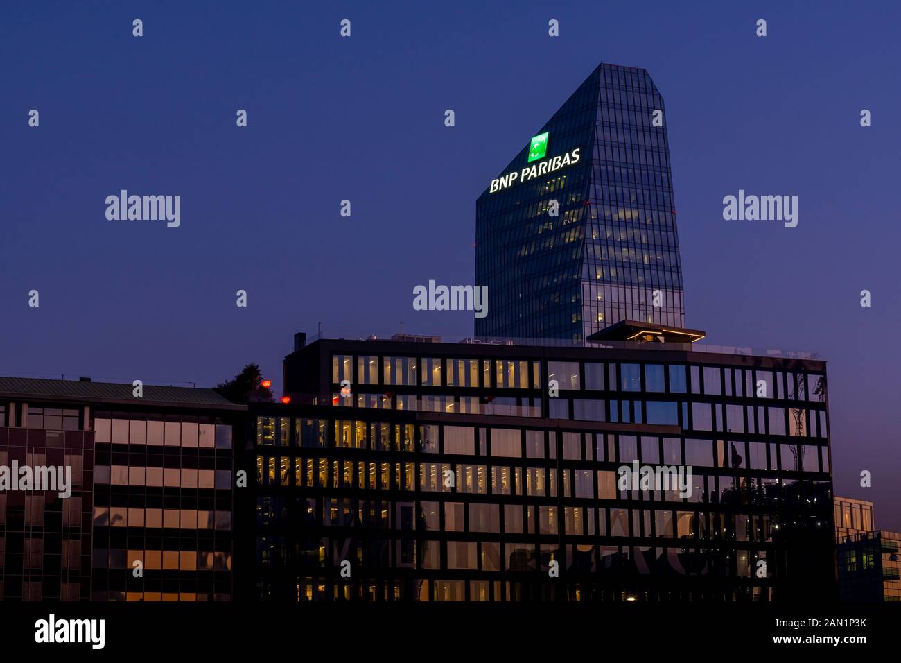 Edificio in vetro sede della banca francese BNP Paribas con il logo illuminato di segno al tramonto. Milano, Italia. Foto Stock