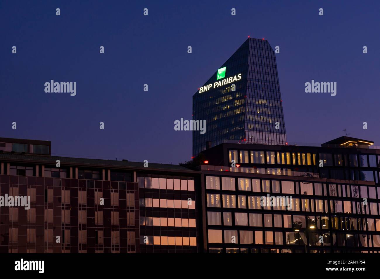 Edificio in vetro sede della banca francese BNP Paribas con il logo illuminato di segno al tramonto. Milano, Italia. Foto Stock