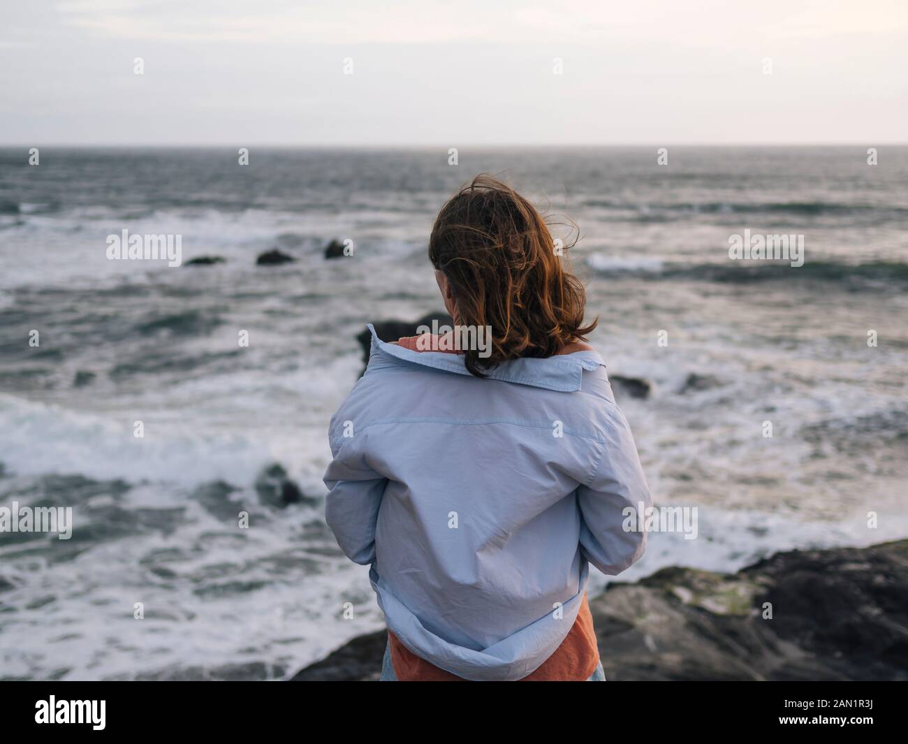 Giovane donna che guarda l'oceano Foto Stock