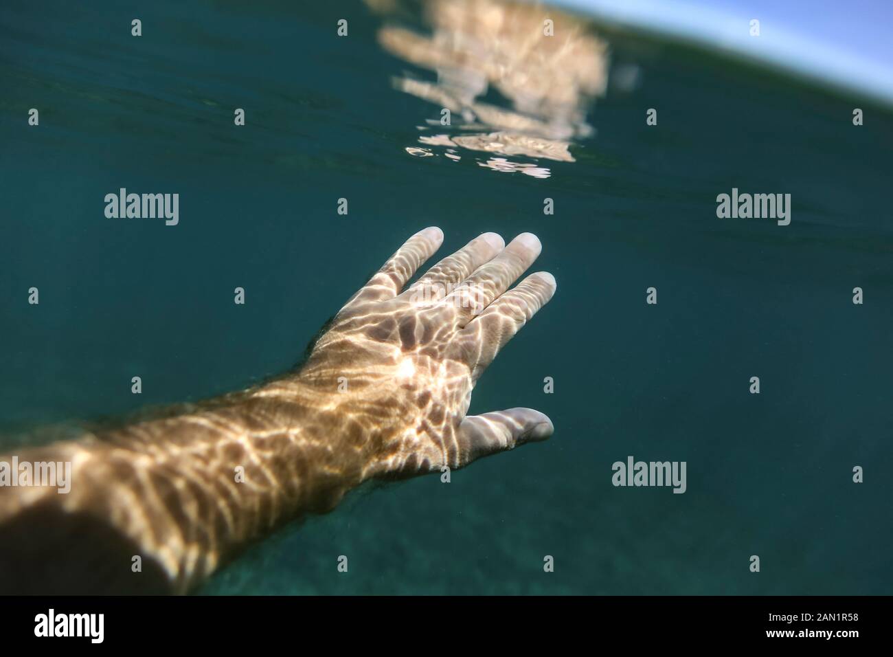 Persona irriconoscibile che nuota sotto l'acqua Foto Stock