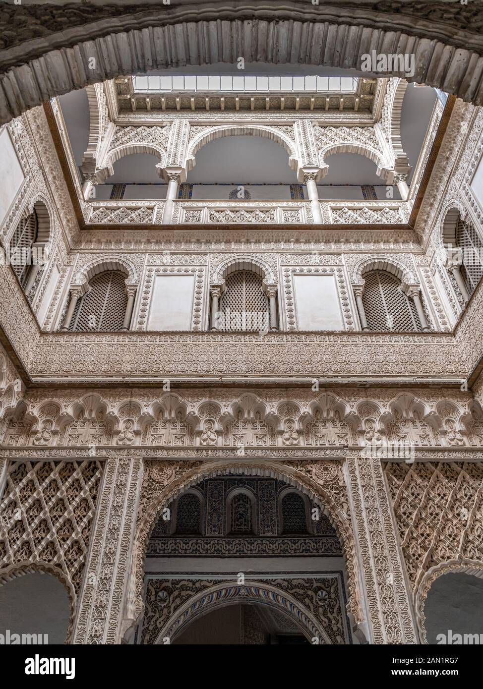 Il patio de las Muñecas (cortile delle bambole) nel Real Alcázar, con la sua vasta decorazione Mudejar su tutti e tre i livelli. Foto Stock