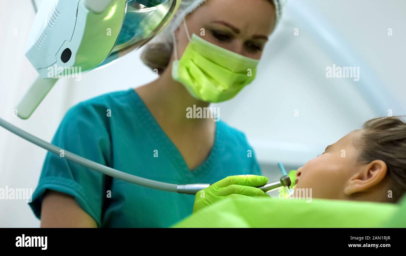 Tipo di perforazione del dentista ragazza adolescente dente, professional stomatologia pediatrica Foto Stock