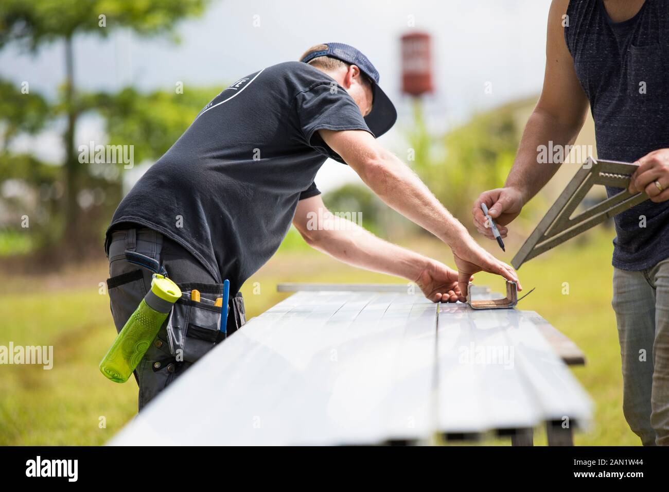 Due uomini che segnano misure su escursione in acciaio per pannelli solari. Foto Stock