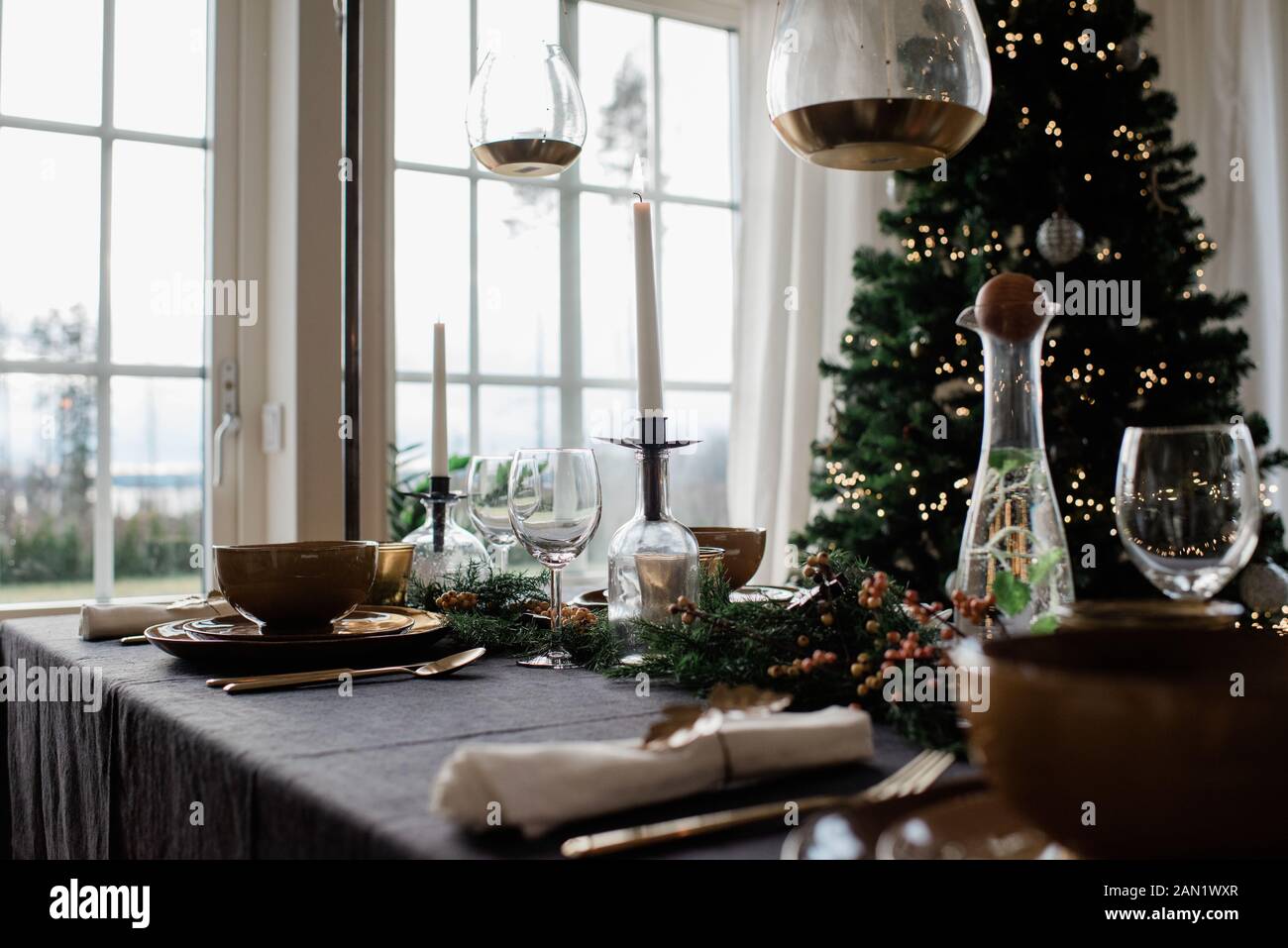 Candela alta illuminata su un tavolo da pranzo decorato festivo a Natale Foto Stock