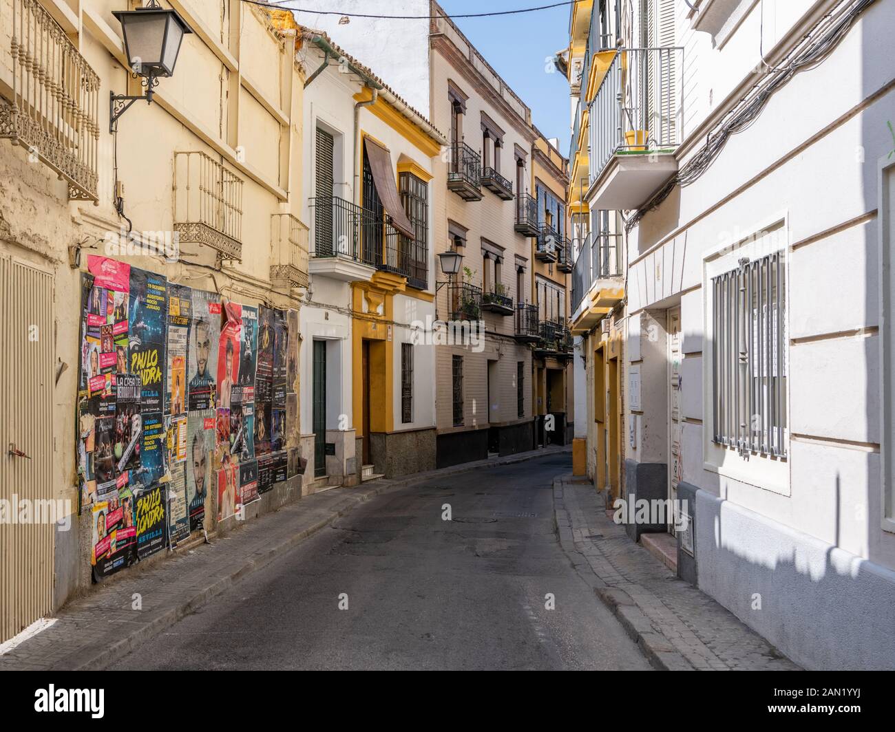 Una parete affollata di poster che pubblicizzano spettacoli di intrattenimento in una tranquilla strada residenziale a Siviglia Foto Stock