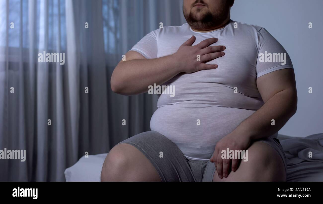 Maschi obesi che soffrono di dolore al petto, pressione del sangue alta, livello di colesterolo Foto Stock