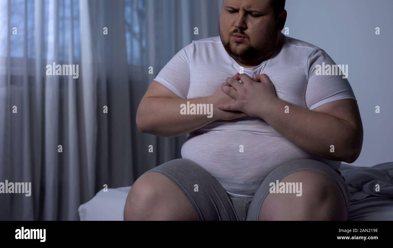 Uomo sovrappeso che soffrono di dolore al petto, pressione del sangue alta, livello di colesterolo Foto Stock