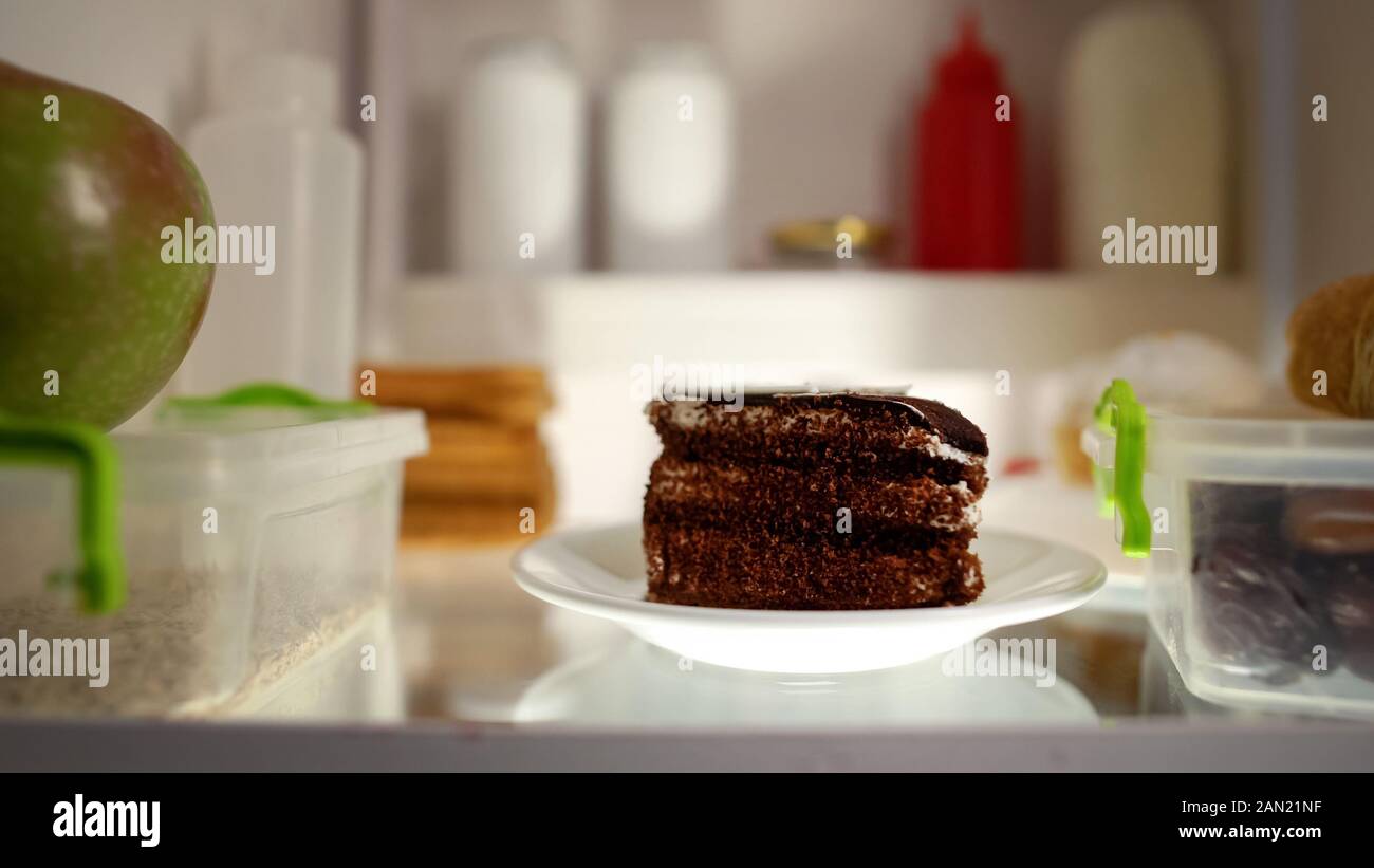 Primo piano della torta di cioccolato all'interno del frigo e malsano, nutrizione, ad alto contenuto calorico pasto Foto Stock