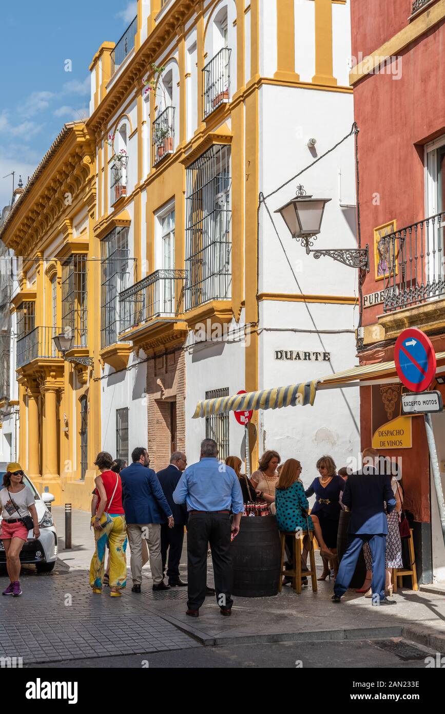 Amici e familiari si riuniscono per un drink a pranzo in un piccolo bar del quartiere di Calle Pureza, Triana, Siviglia. Foto Stock