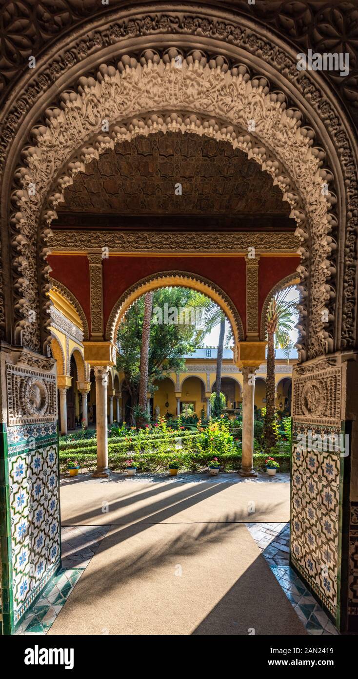 Il patio andaluso in stile Palm Tree Courtyard del Palacio de las Dueñas attraverso archi Mudéjar decorati con ornamento Foto Stock