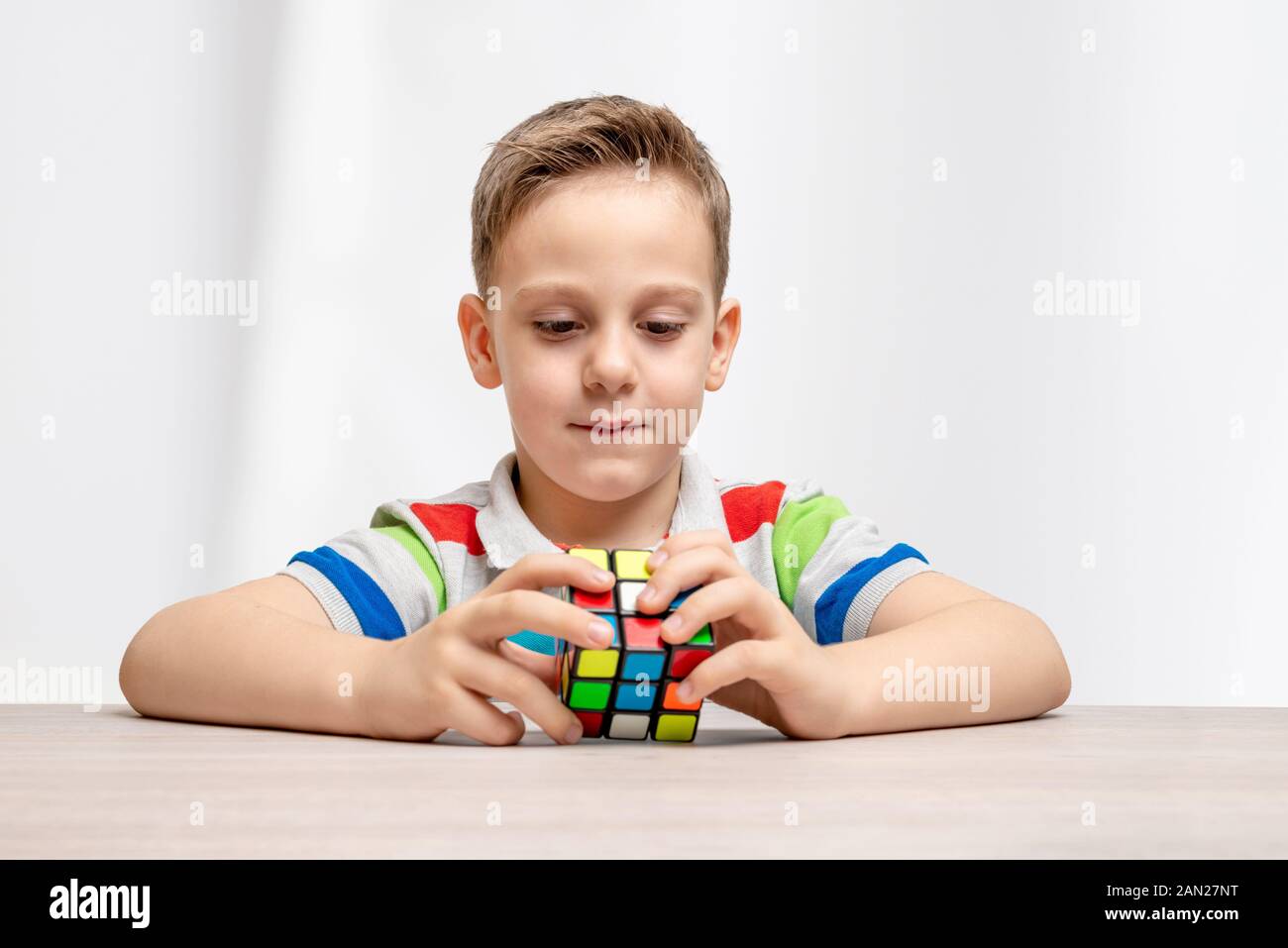 Kid assembla un cubo di Rubik. Concetto di hobby, giocare e risolvere enigmi. Close-up Foto Stock