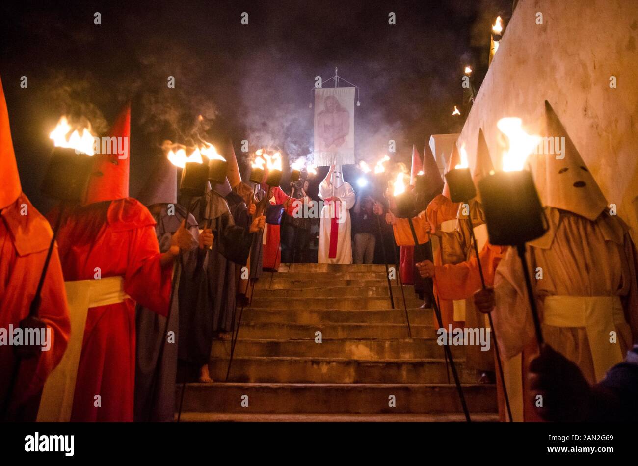 Incappucciati delle persone che fanno il tradizionale Fogaréu processione attraverso le vie della città di Goiás, Brasile Foto Stock