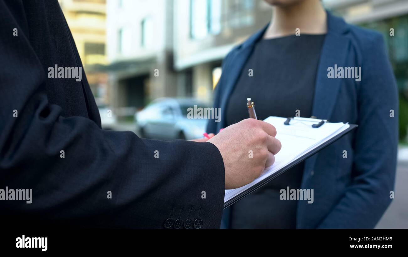 Personale assistente femmina in attesa mentre boss maschio firma contratto nei pressi di office Foto Stock