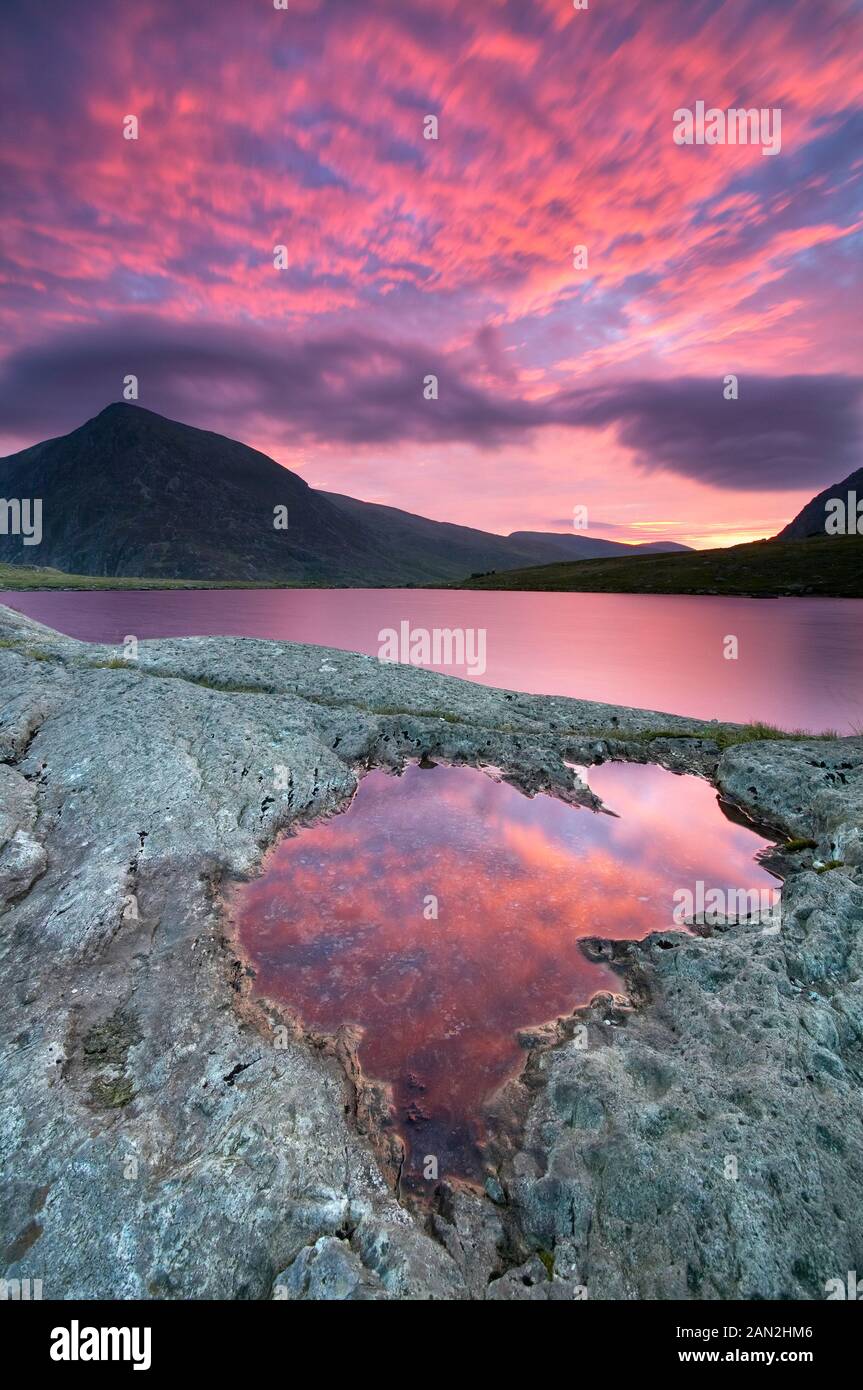 Sunrise Llyn Idwal lago glaciale, Cwm Idwal, Dafydd Carnedd Mountain in background, Snowdonia, Galles Foto Stock