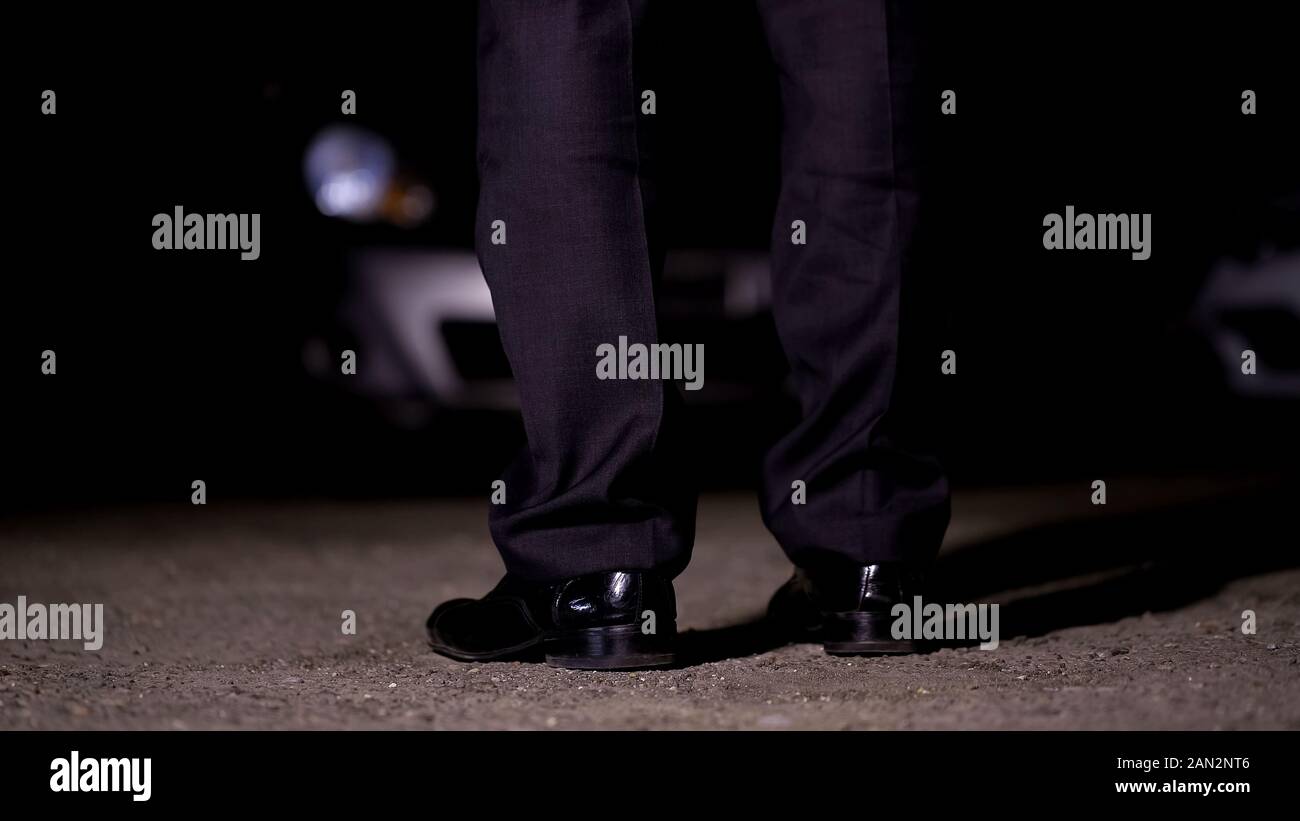 Uomo in piedi nella parte anteriore della macchina sul parcheggio, andare in discoteca party, intrattenimento Foto Stock