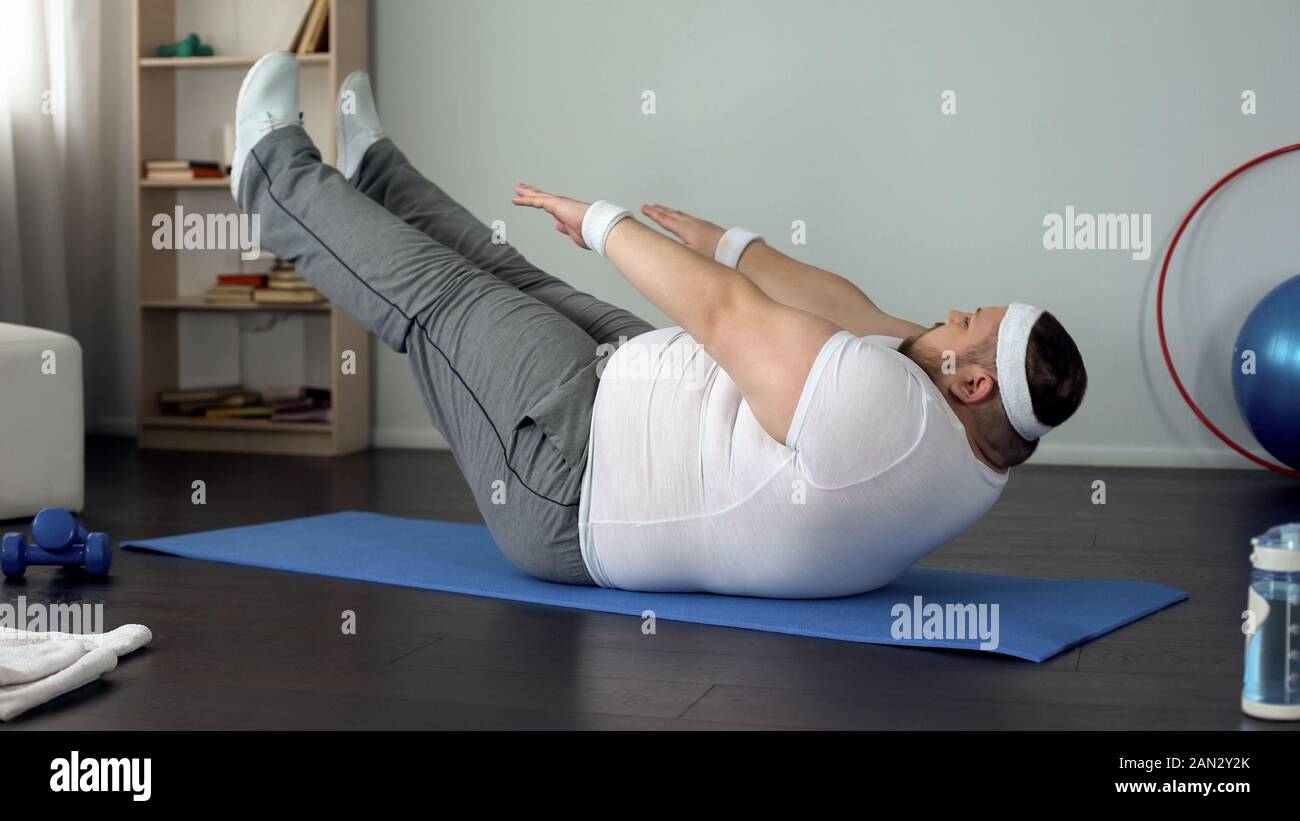 Fat Man praticando addominali esercizio statico, la resistenza e la durata dello sviluppo Foto Stock