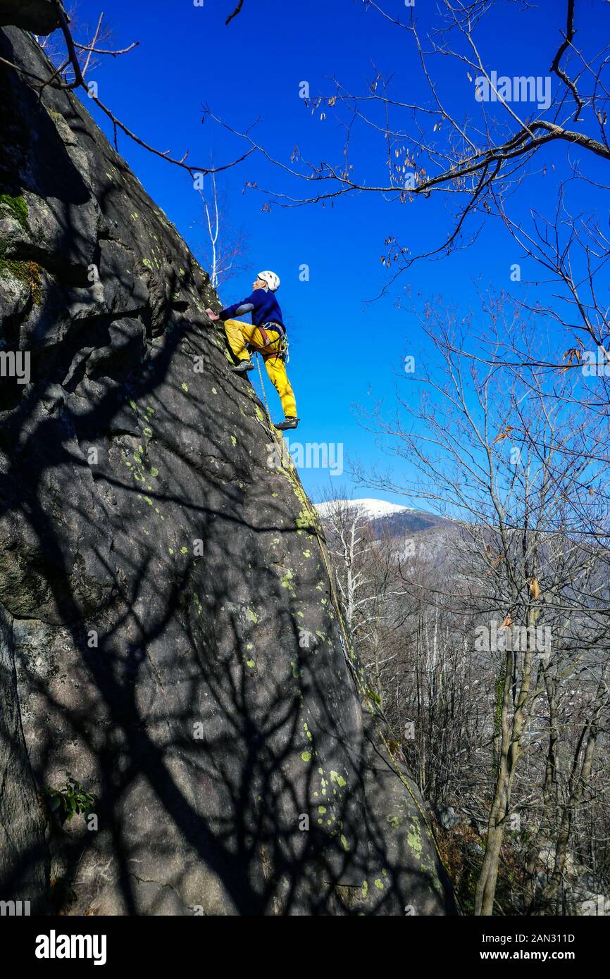 Maschio di rocciatore, 70 anni, arrampicata su roccia di granito a Auzat, Pirenei francesi, Francia Foto Stock