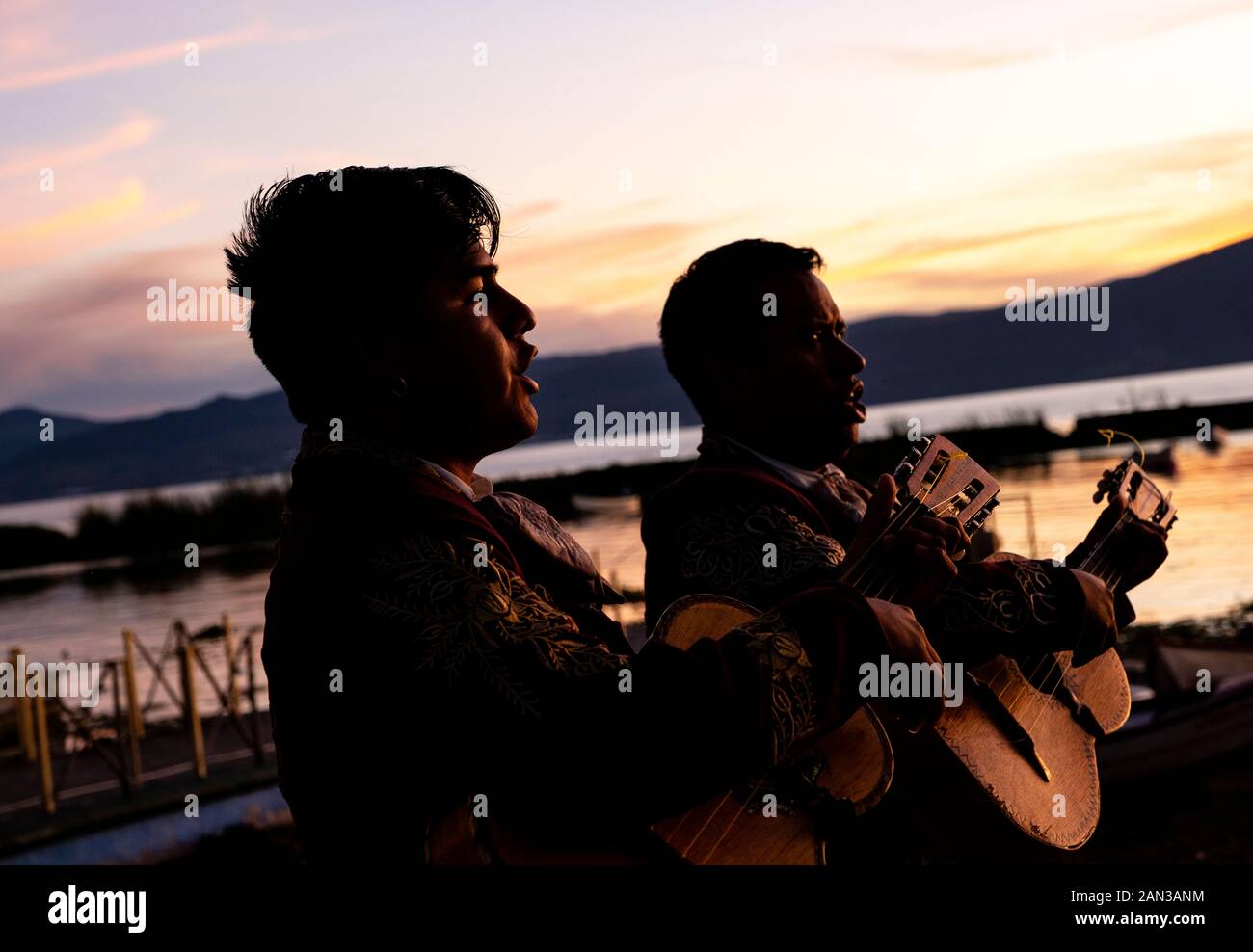 Musicisti Mariachi di cantare e suonare la chitarra durante un tramonto nel lago Chapala, Messico Foto Stock