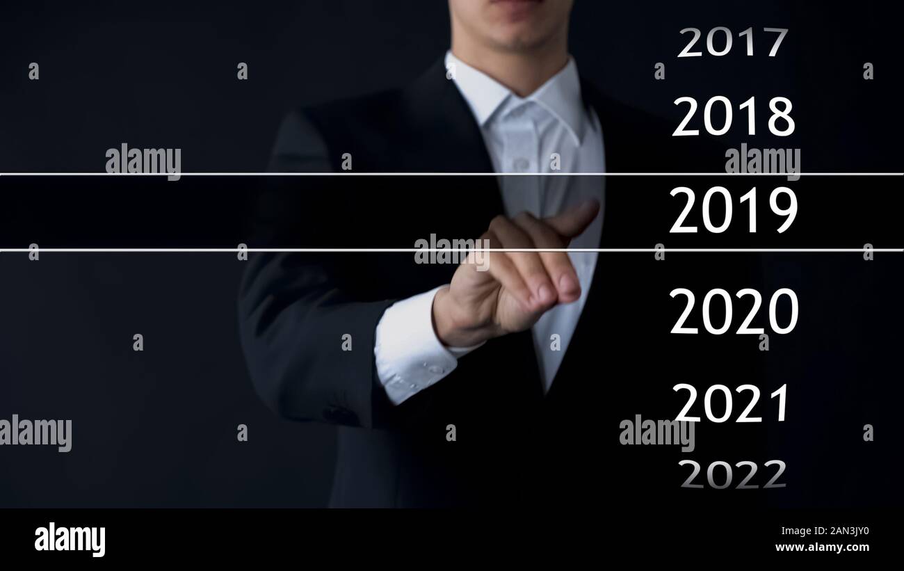 Imprenditore seleziona 2019 anno nel menu virtuale, ricerca di dati, business history Foto Stock