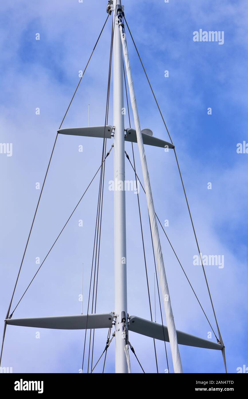La metà superiore della barca a vela il montante con crocette e sartiame e ammainando headsail. Foto Stock