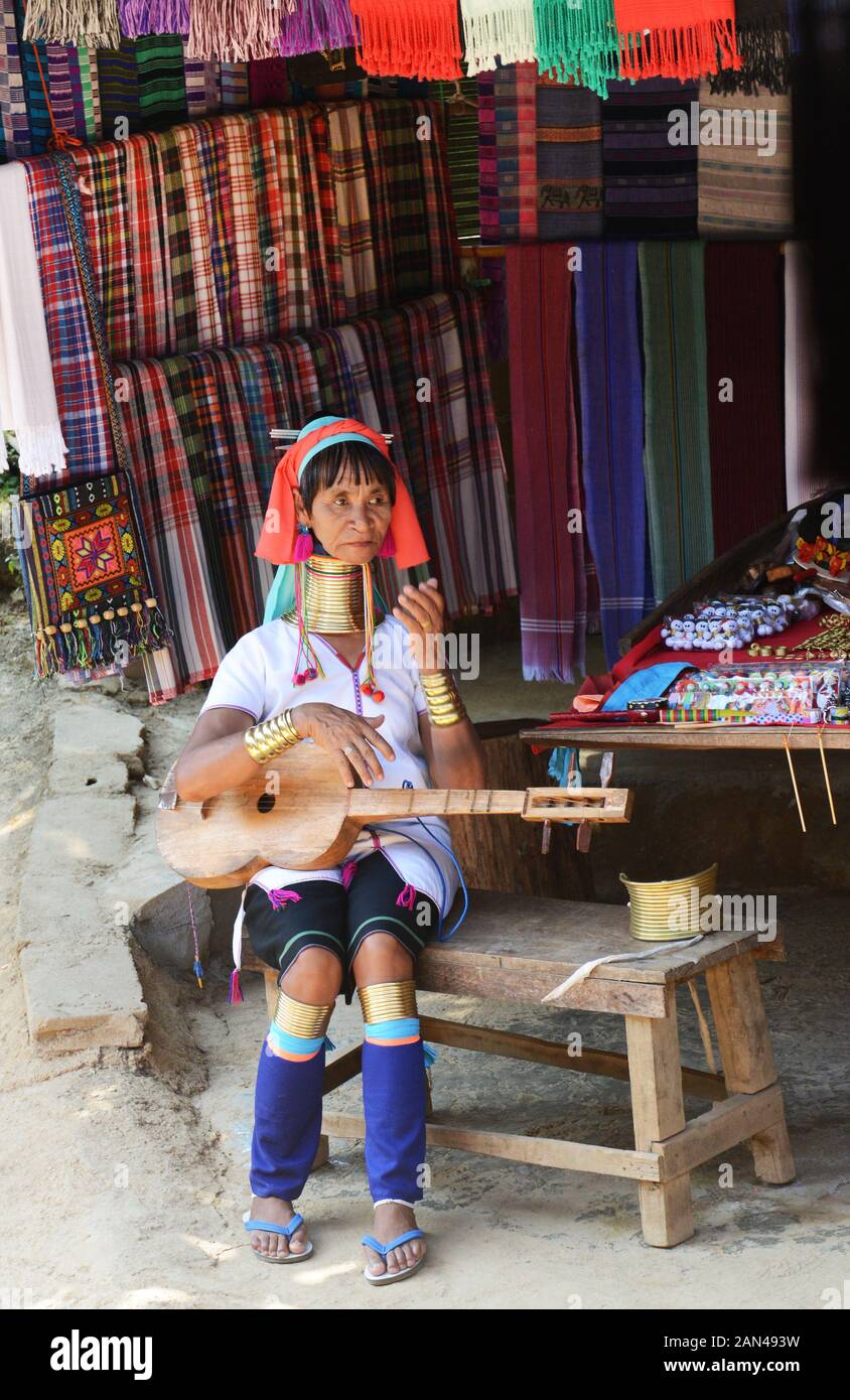 Una donna Padaung riproduzione di un tradizionale strumento a corda. Foto Stock