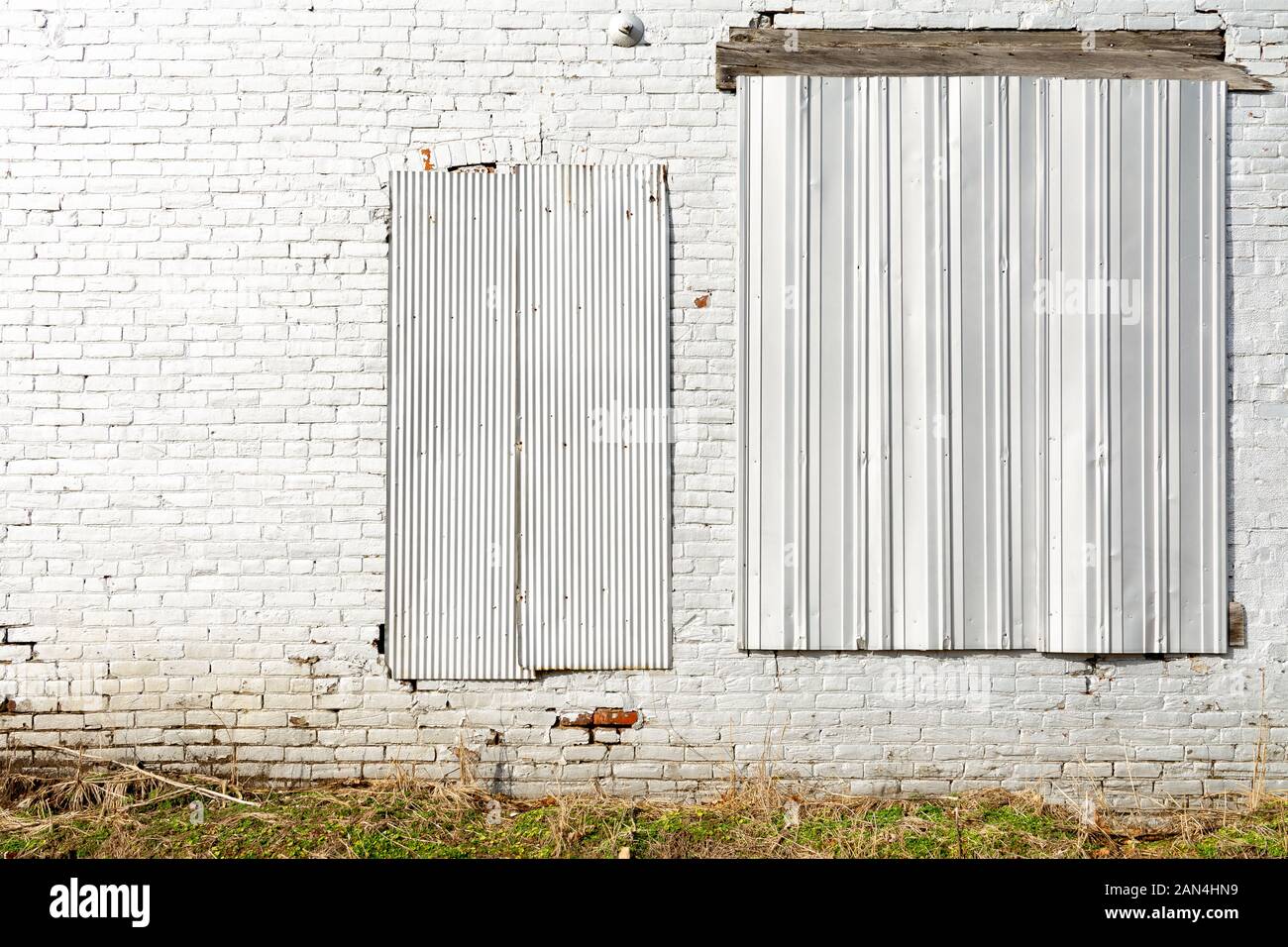 Bianco vecchio muro di mattoni sulla parete esterna del vecchio mulino nel Midwest. Foto Stock
