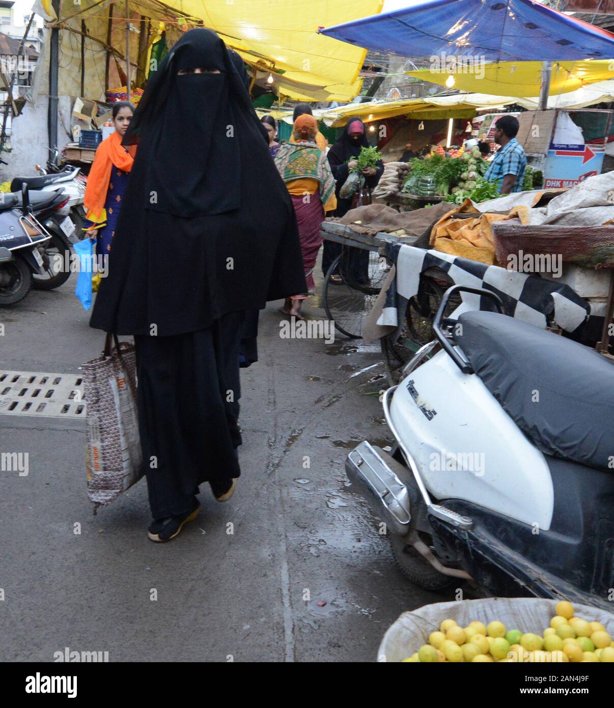 Una donna musulmana indiana velata che cammina attraverso il mercato di Pune, India. Foto Stock