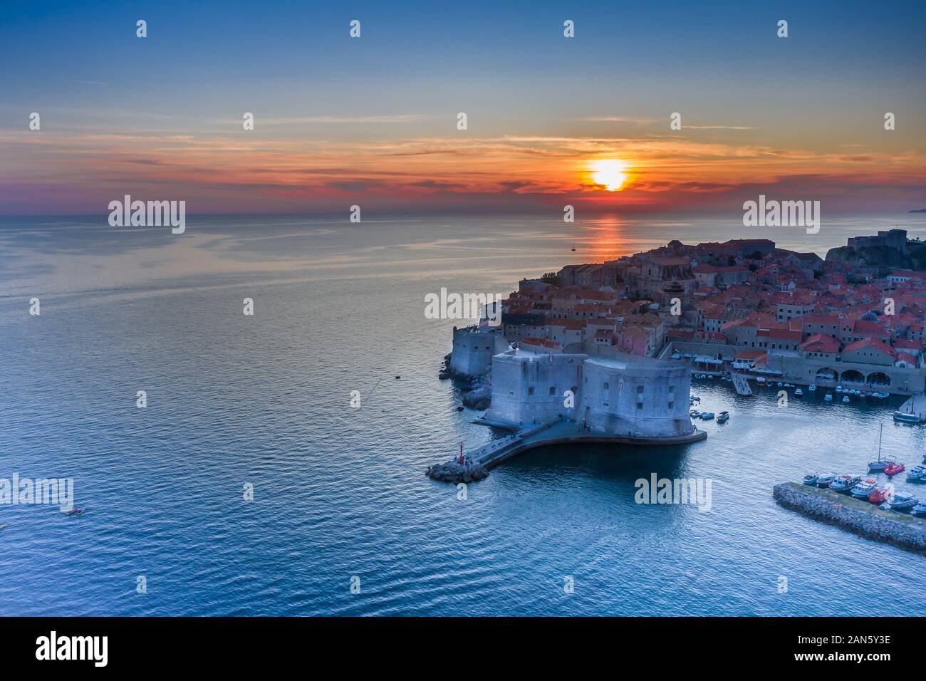 Costa croata che rivela la città vecchia di Dubrovnik e le mura della città al tramonto.Città vecchia europea e mare Adriatico.Spiaggia di Banje a Dubrovnik, Dalmazia regione Foto Stock