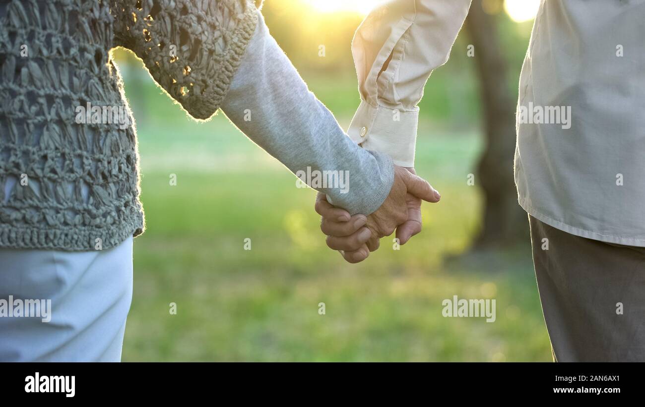 Età compresa tra marito e moglie Holding Hands, stare insieme e i romantici, close-up Foto Stock