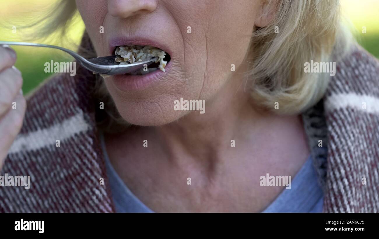 Old Lady mangiare porridge, carità pasti per pensionati poveri, riforma sociale Foto Stock