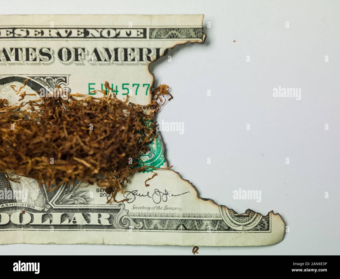 Il tabacco da fiuto su un dollaro, bruciato denaro Foto Stock