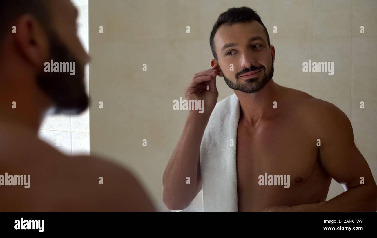Uomo orecchio di pulizia con il bastoncino di cotone in bagno, procedura di mattina, healthcare Foto Stock