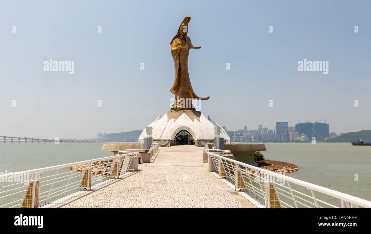 Ponte / percorso che conduce verso la statua Kun Iam (noto anche come Guan Yin o Guanyin - una bodhisattva femminile). Sullo sfondo il mare e il cielo di Macao Foto Stock