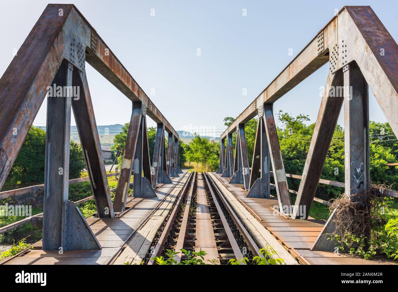 Vista sul ponte con binari ferroviari e supporto in acciaio. Arrugginito, sfondo. Concetto per teambuilding, via avanti, dritto, connessione, vecchio ma solido. Foto Stock