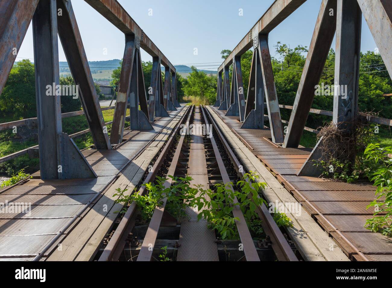 Vista diritta su ponte massiccio con supporto in acciaio su ciascun lato. Binari ferroviari. Simbolo / concetto per connessione, comunicazione. Foto Stock