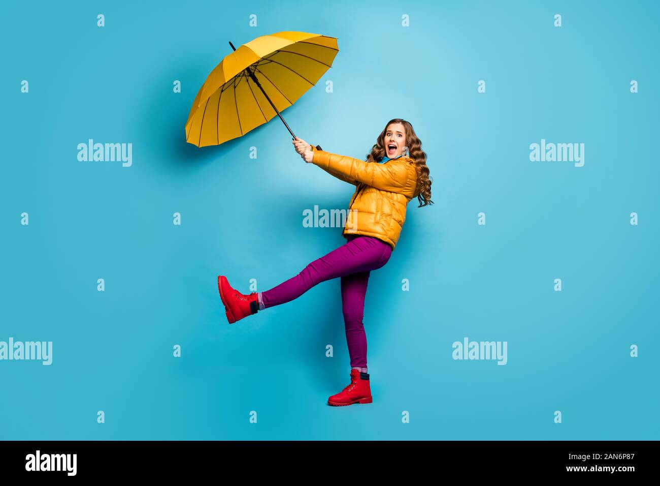 Help me. La piena dimensione della foto del profilo di Crazy scioccato lady tenere ombrello volare con vento che soffia usura sovrarivestimento giallo sciarpa viola pantaloni calzature rosso Foto Stock