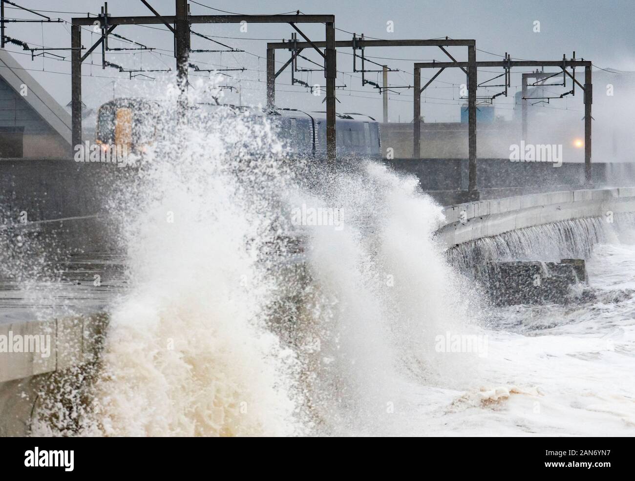 Grandi onde si infrangono sulla strada e la linea ferroviaria a Saltcoats durante la tempesta Brendan il 13 gennaio 2020. Ayrshire, in Scozia, Regno Unito Foto Stock