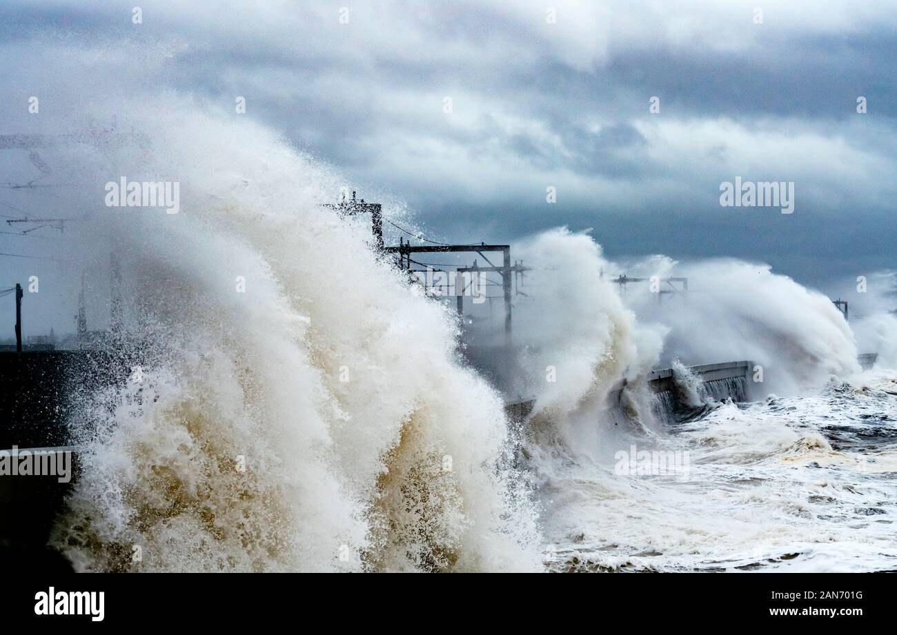Grandi onde si infrangono sulla strada e la linea ferroviaria a Saltcoats durante la tempesta Brendan il 13 gennaio 2020. Ayrshire, in Scozia, Regno Unito Foto Stock