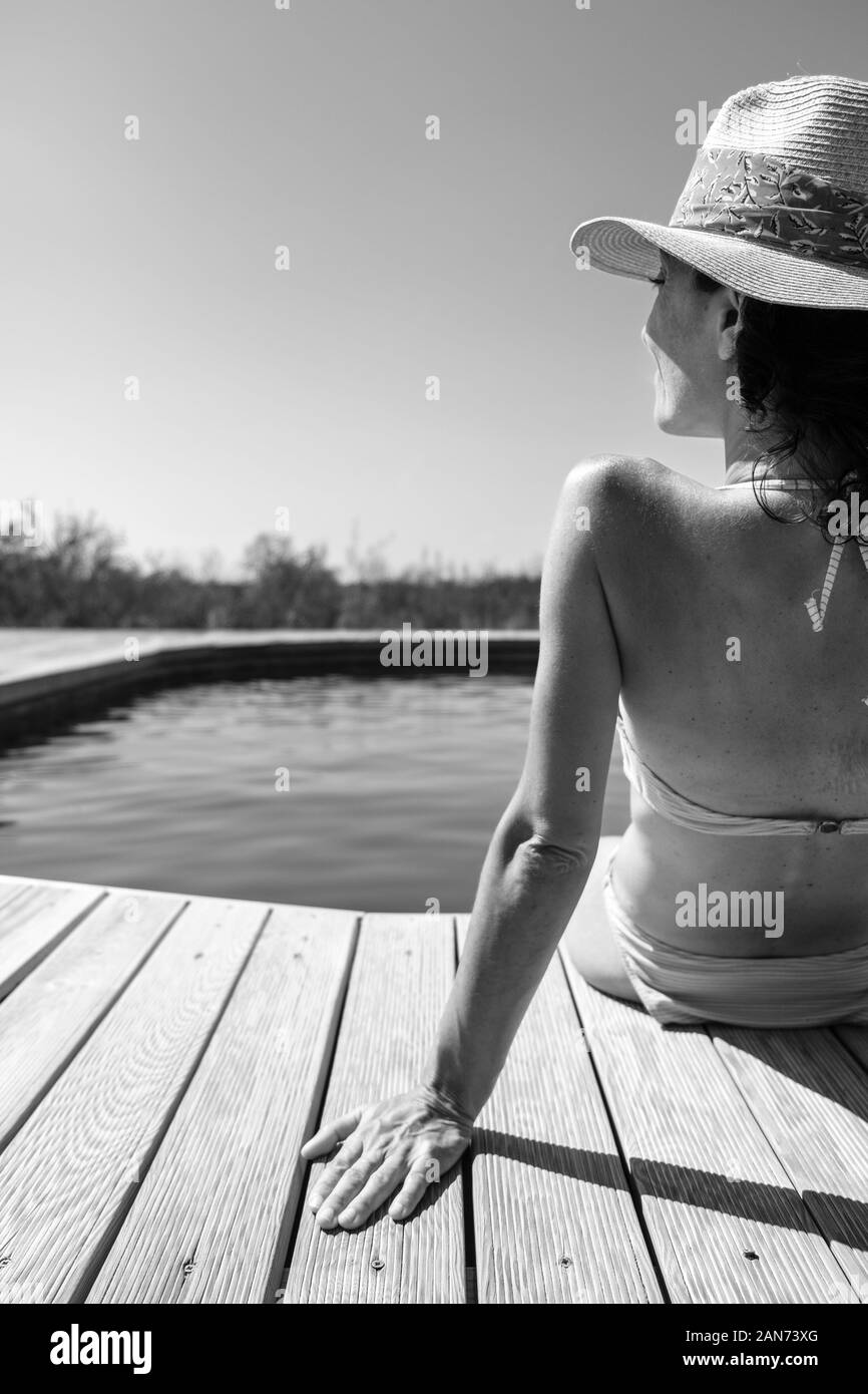 White donna seduta sul bordo di una piscina in classico in bianco e nero Foto Stock