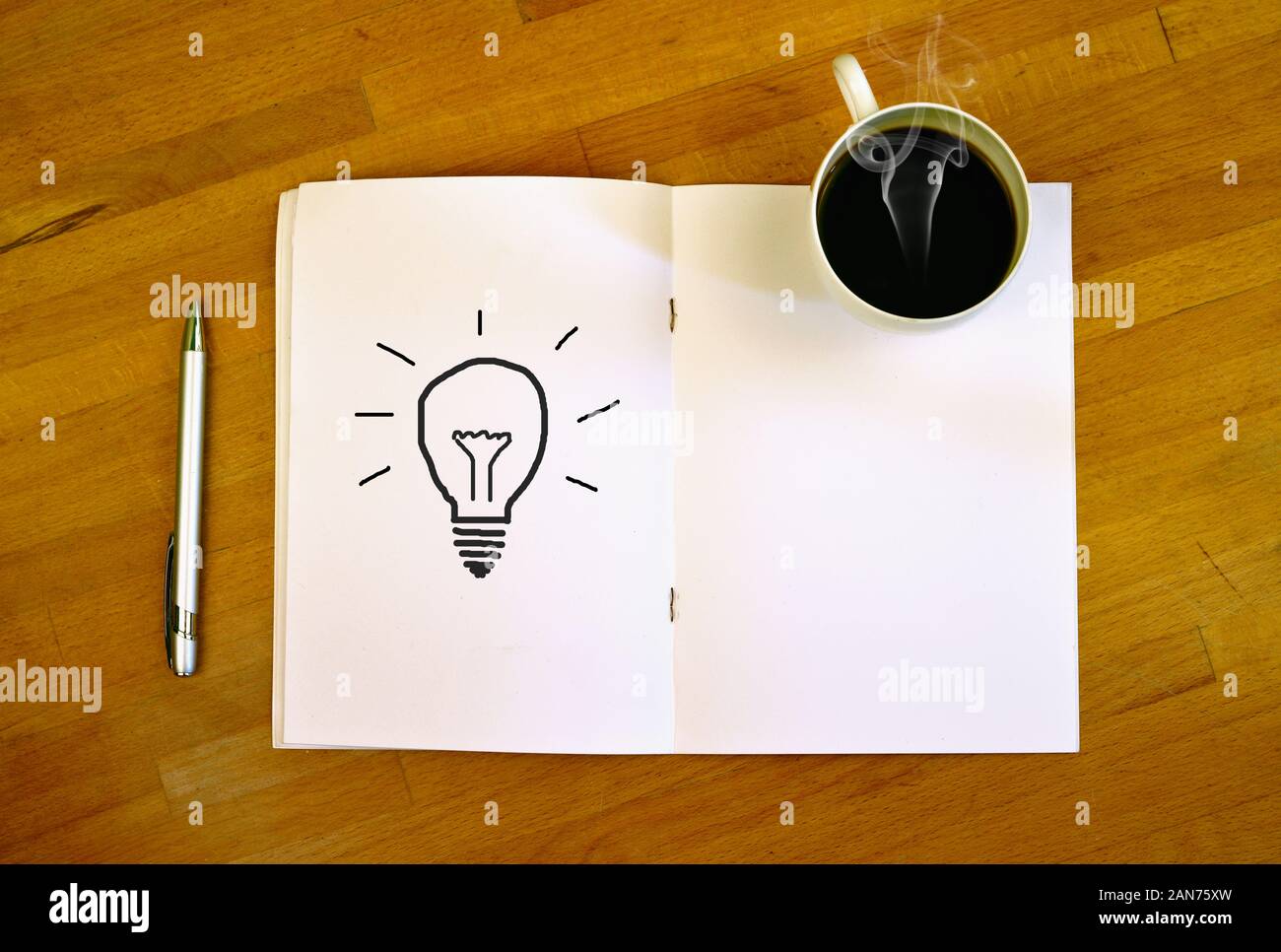 Scrivania con caffè caldo e carta con un simbolo della lampada Foto Stock