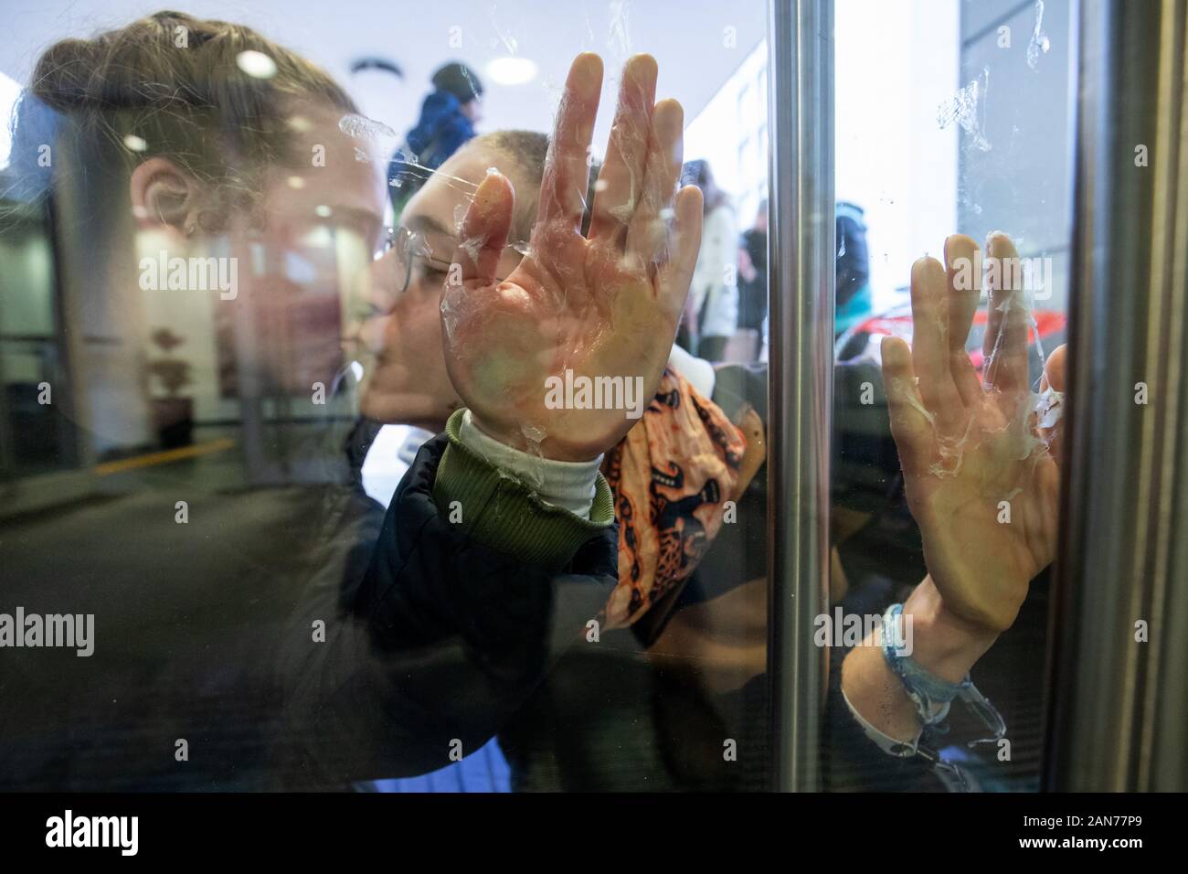 Erlangen, Germania. 16 gennaio, 2020. Gli attivisti del clima del gruppo "ribellione di estinzione' bloccano la porta di ingresso di un Siemens Building a cui hanno bloccato le mani in segno di protesta contro un ordine di Siemens in Australia. Credito: Daniel Karmann/dpa/Alamy Live News Foto Stock