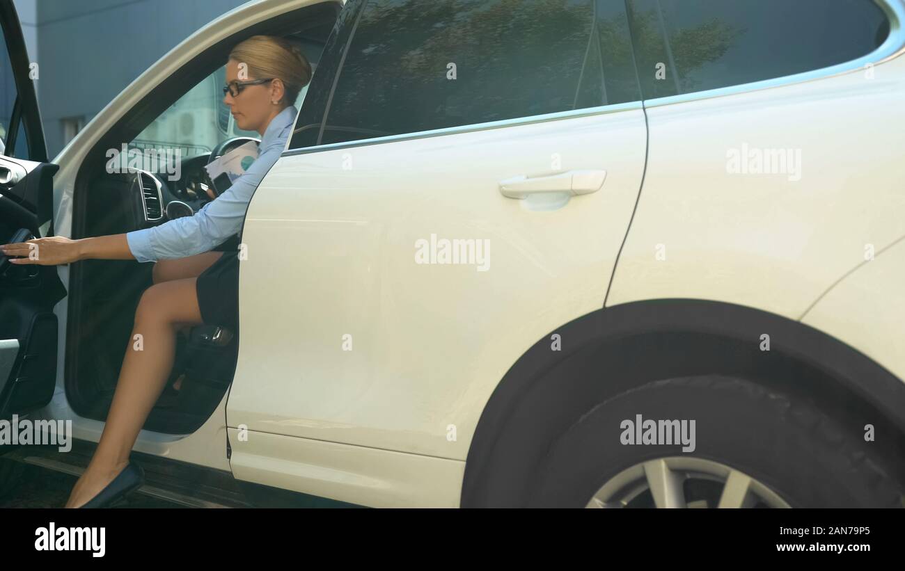 Imprenditrice uscendo di automobile di lusso, successo in carriera e patrimonio Foto Stock