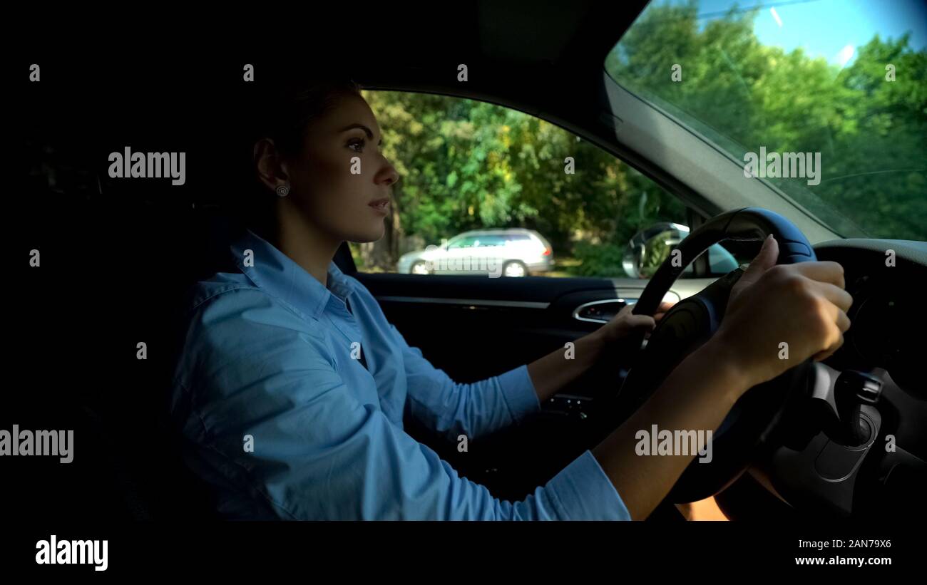 Grave donna cercando parcheggio, attento conducente rispettando le norme della strada Foto Stock