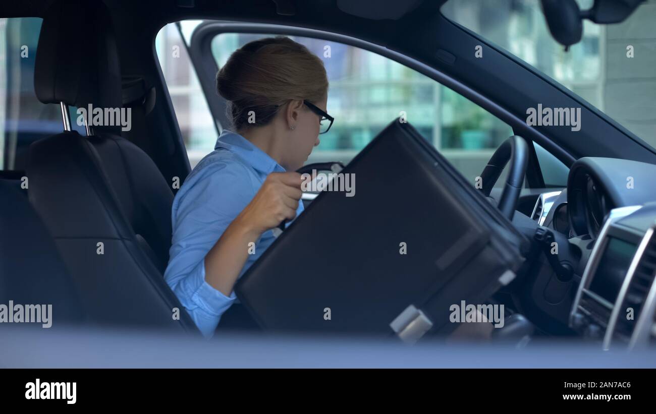 Business donna prendendo nella valigetta e uscire da auto parcheggiate vicino centro uffici Foto Stock