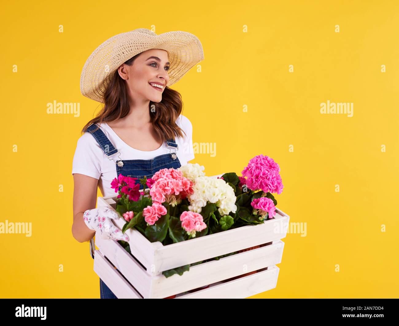 Giovane donna che trasportano casse di legno con splendidi fiori Foto Stock