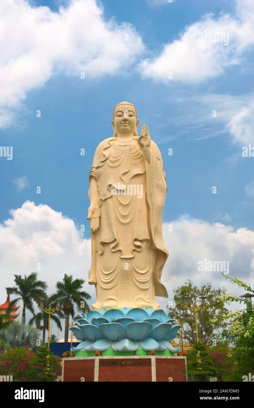 In piedi la statua di Buddha a Vinh Trang tempio, vicino a My Tho, Vietnam. Basso angolo di visione. Foto Stock