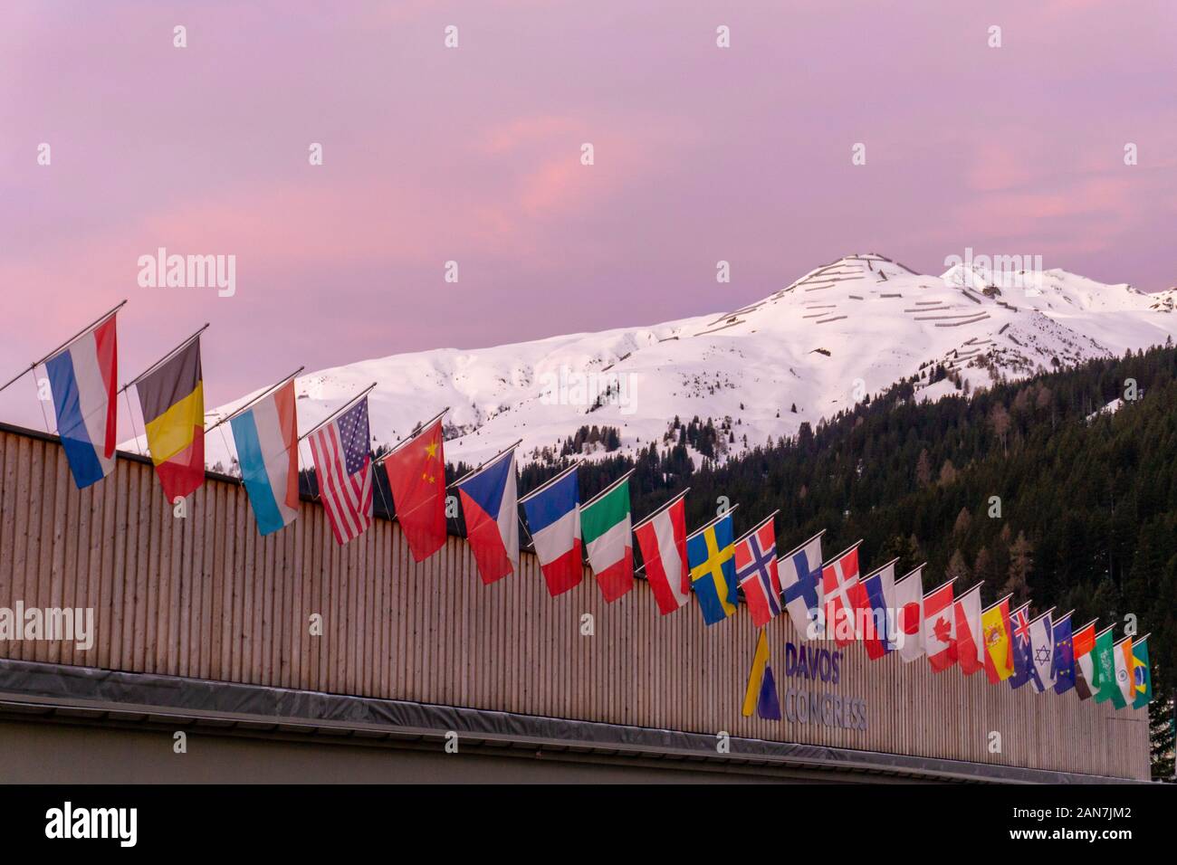 Davos GR / Svizzera - 14 Gennaio 2020: il centro congressi a Davos con le bandiere delle nazioni di sunrise durante il WEF Forum Economico Mondiale Foto Stock