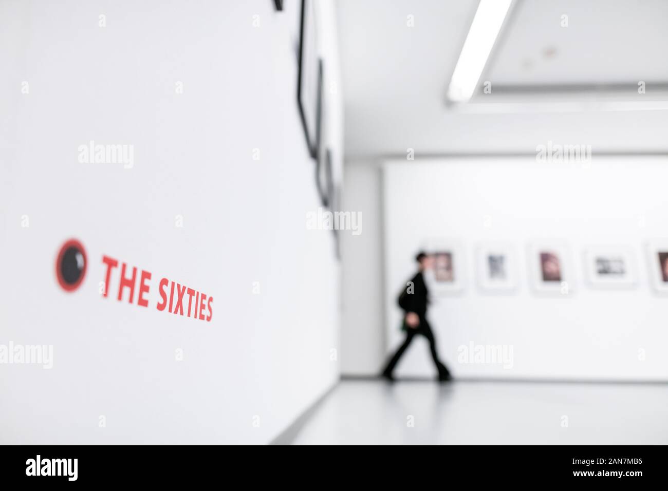 Oberhausen, Germania. 16 gennaio, 2020. 'L'Sixties' sorge su una parete mentre un visitatore in background passeggiate attraverso la mostra. Premere il tasto Conferenza per la mostra 'fotografo tra musicisti: Linda McCartney - Anni Sessanta e più". Sul display sono le foto da Linda McCartney dalla scena della musica alla fine degli anni sessanta: Janis Joplin, Jimi Hendrix, Aretha Franklin, i Beatles e i Rolling Stones e altri. In aggiunta, la mostra è dedicata ai lavori stradali come McCartney il contributo al cosiddetto street photography. Sul display sono 180 opere. Credito: Fabian Strauch/dpa/Alamy Live News Foto Stock